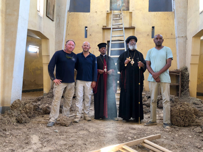 HALO staff stand with religious leaders inside the cleared church