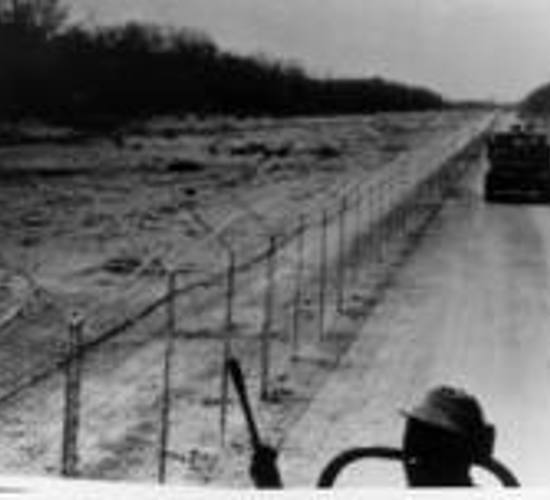 Black and white archival photo of guards patrolling a minefield in Zimbabwe