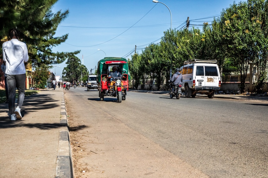A street in Huambo which used to be a minefield, now shows a bustling road with vehicles and pedestrians