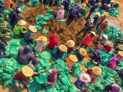 A group of villagers fill sandbags in Laos