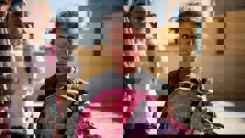 Syrian girl holding a backpack and smiling