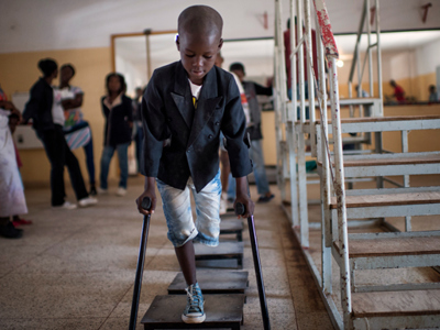 A little boy called Manuel practices walking with crutches in Huambo rehab centre Angola
