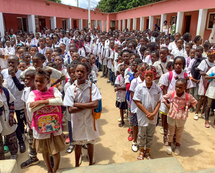 kids stand outside Kambulukuto School, Cuito, Angola
