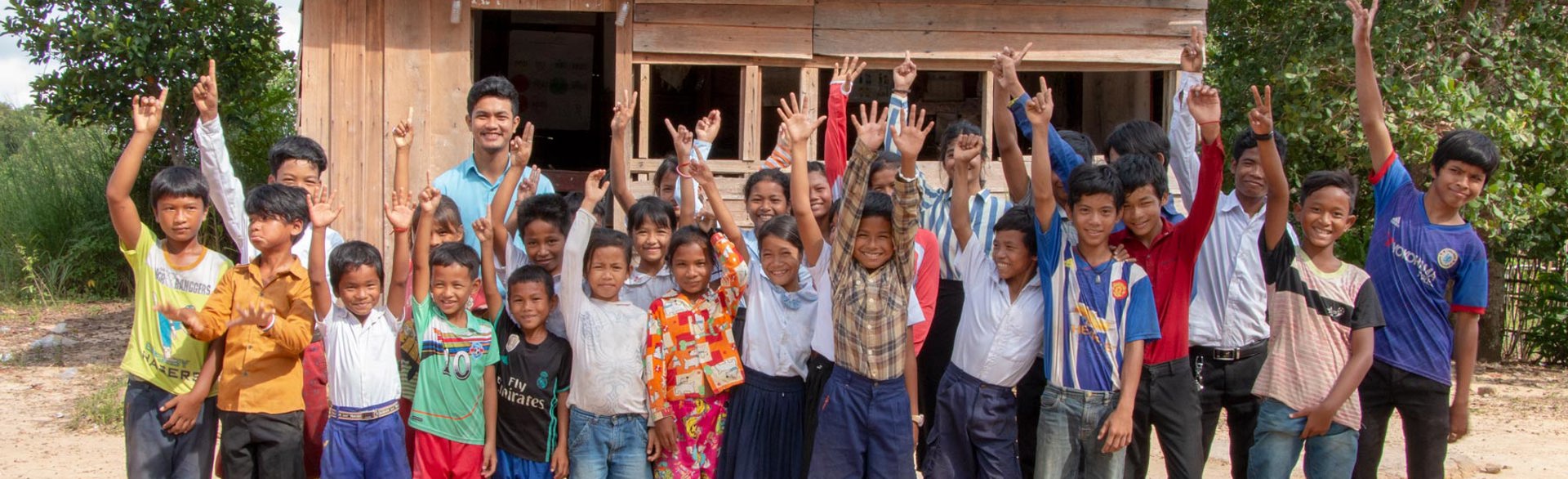 A large group of children waving in Cambodia