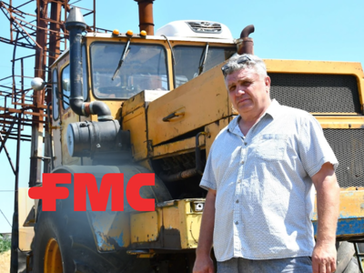 Serhii Kishkovskyi, a Ukrainian farmer stands in front of his farming vehicle in a field